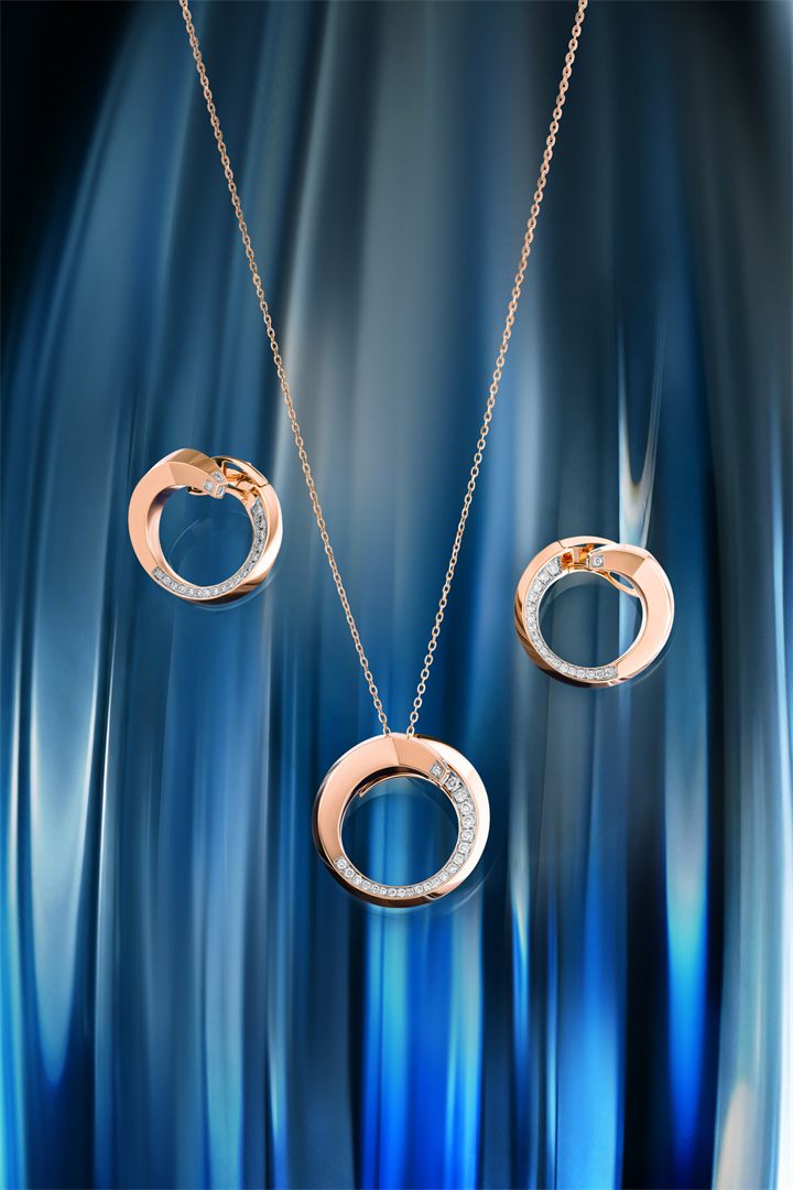 Rose gold circle pendant and earrings against blue fluted glass