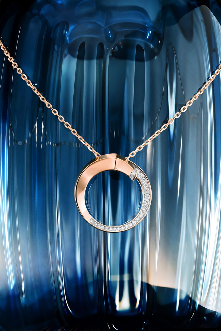 Rose gold circle pendant and earrings against blue fluted glass