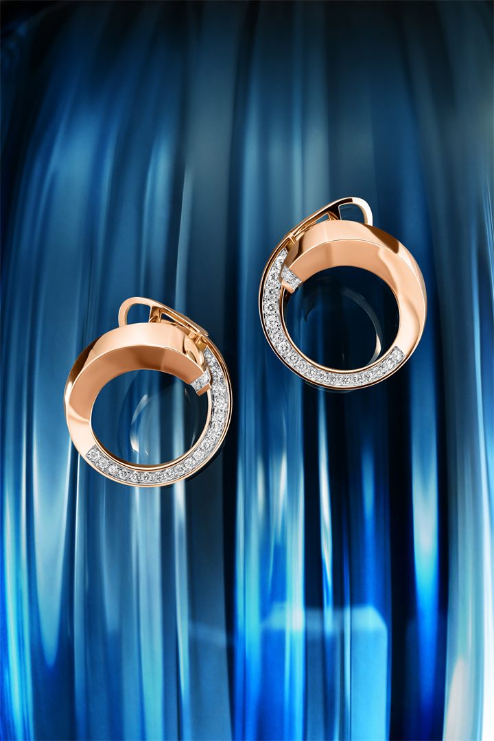Rose gold circle pendant and earrings against blue fluted glass