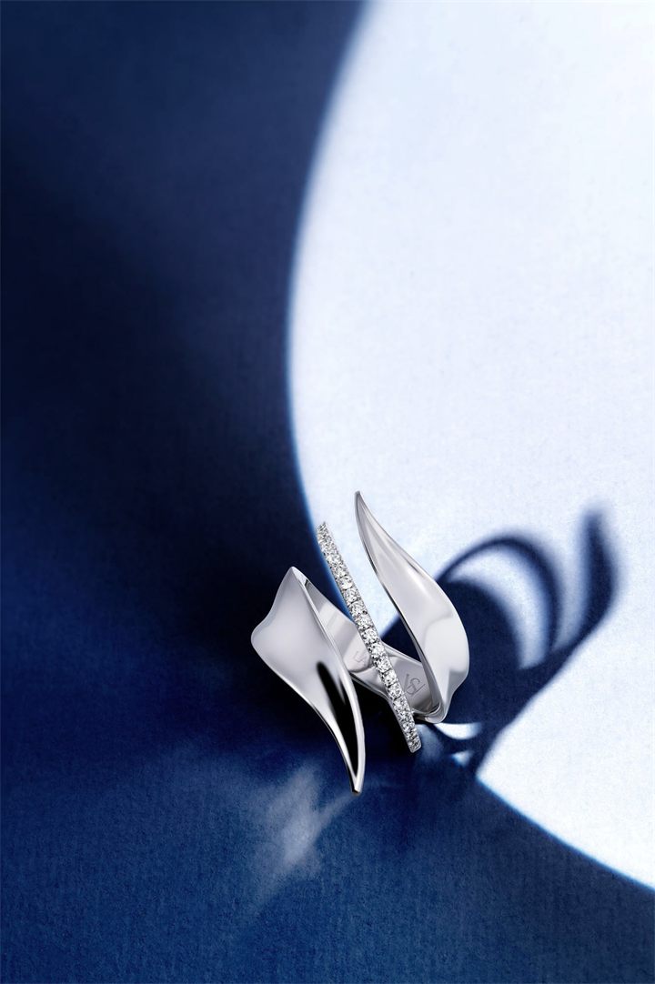 White gold diamond wing ring on navy with directional light